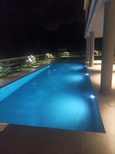 a blue swimming pool lit up at night at Hotel Vita in Salò
