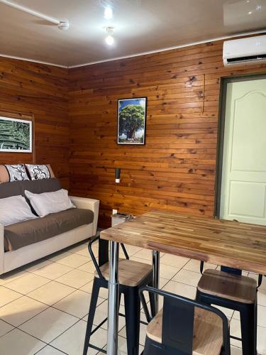 a living room with a bed and a table at GITE-Hotel LA CAZ DES ORANGERS in Le Bois de Nèfles