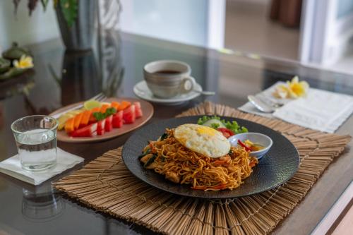 a plate of spaghetti and an egg on a table at Eiwa House in Ubud