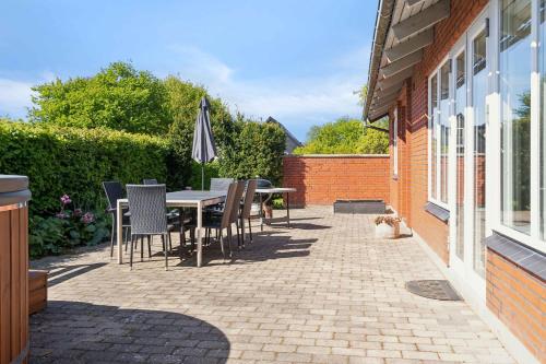 a patio with a table and chairs and an umbrella at Lovely Holiday Home With Hot Tub 150 M To Water in Fur