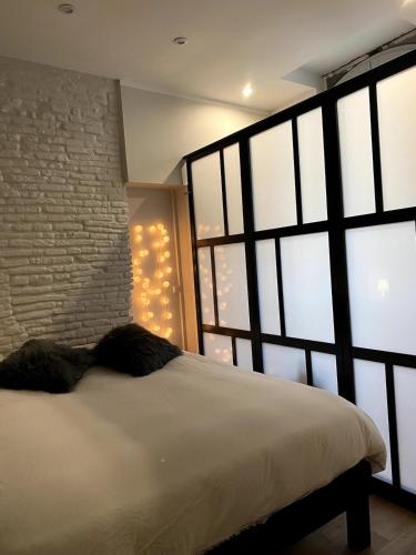 une chambre avec un lit blanc et un mur de briques dans l'établissement T2 historic district of Carmes, à Toulouse