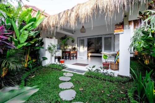 a garden in front of a house with a patio at Eiwa House in Ubud