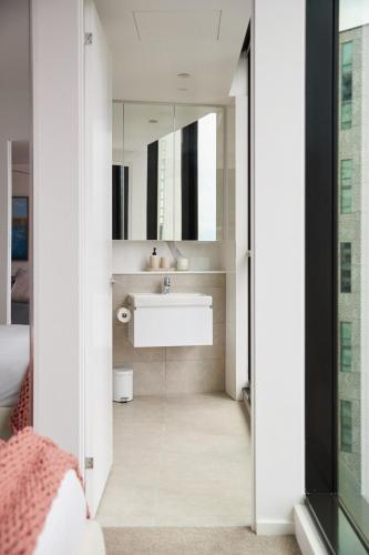 a bathroom with a sink and a mirror at City Escape - 8 mins From Flinders St - Pool & Gym in Melbourne