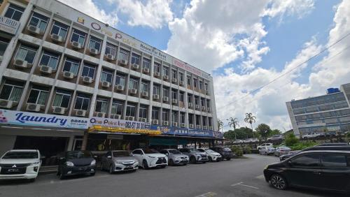 a large building with cars parked in front of it at One Point Inn King Centre in Kuching