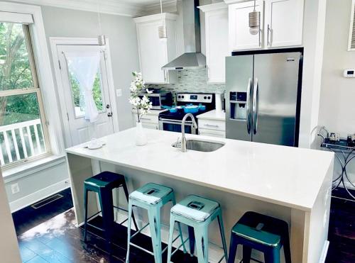 a kitchen with a counter with stools around it at Gorgeous Modern 4-Level 4BDR Home in Central Location Parking Included Free Cancellation in Washington, D.C.