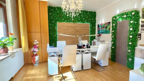 a dining room with a green wall with a table and chairs at Pension Cao Lai in Varel