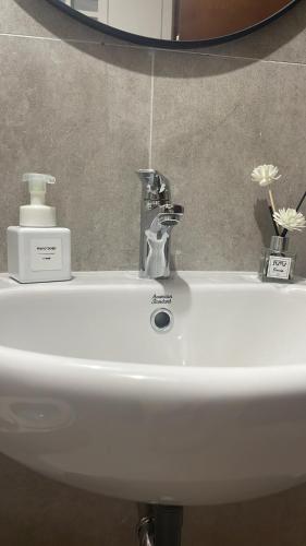 a white sink with a faucet and a mirror at Pollux Habibie Lvl 52 Sea View Studio with Gym,Pool & Netflix in Batam Center