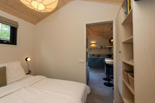 a small bedroom with a bed and a kitchen at Boswilg in Zuidwolde