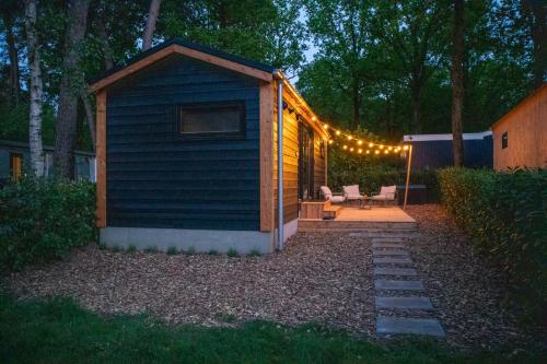 a shed with lights on it in a yard at Boswilg in Zuidwolde