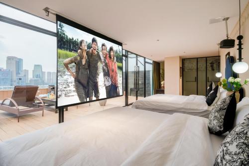 a large screen in a bedroom with two beds at 重庆大野江景民宿 in Chongqing