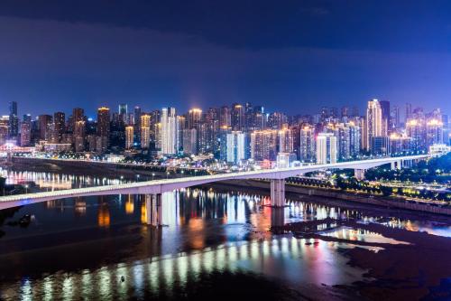 a view of a city at night with a bridge at 重庆大野江景民宿 in Chongqing