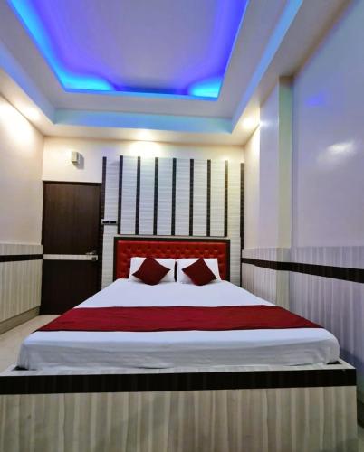 a bedroom with a bed with a blue ceiling at Hotel Ellora In Cooch Behar in Koch Bihār