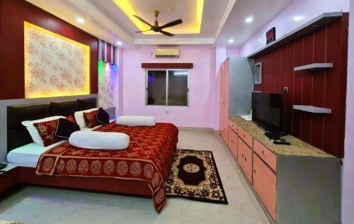 a bedroom with a bed and a flat screen tv at Hotel Ellora In Cooch Behar in Koch Bihār