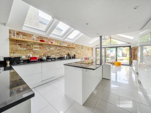 a kitchen with white cabinets and a brick wall at Stunning 3BR Townhouse - Central Oxford Pass the Keys in Oxford