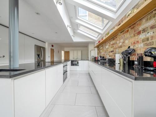 a kitchen with white cabinets and a brick wall at Stunning 3BR Townhouse - Central Oxford Pass the Keys in Oxford
