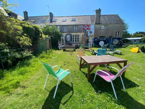 einem Picknicktisch und Stühlen vor einem Haus in der Unterkunft Auberge du Lama Zébré in Penmarcʼh