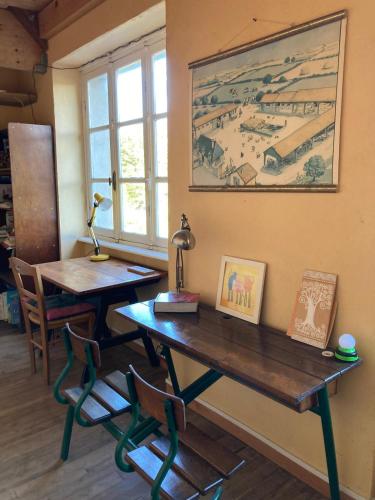 Cette chambre comprend un bureau, une table et une fenêtre. dans l'établissement Auberge du Lama Zébré, à Penmarcʼh