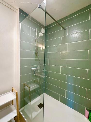 une salle de bain avec une douche avec une porte vitrée dans l'établissement La Nomiane, à Maromme
