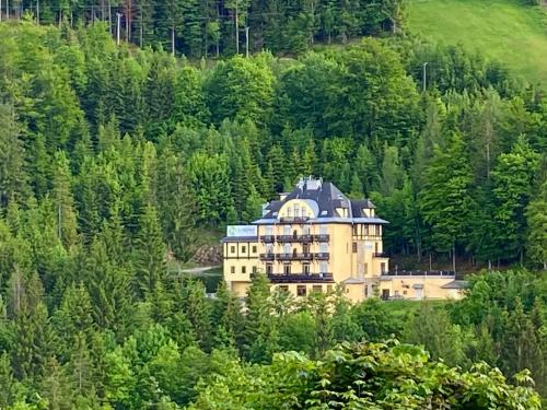 a large building in the middle of a forest at Kurhotel Renona Rehabilitation in Semmering
