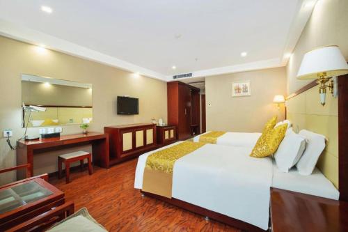 a hotel room with a large bed and a bathroom at GreenTree Inn Taiyuan PinGYAng Road Business Hotel in Taiyuan
