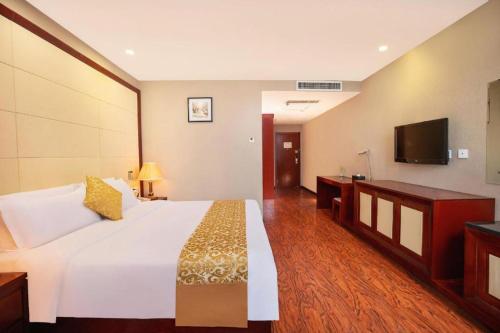 a bedroom with a large white bed and a flat screen tv at GreenTree Inn Taiyuan PinGYAng Road Business Hotel in Taiyuan