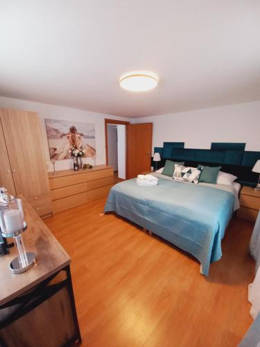 a bedroom with a blue bed and a wooden floor at Willa Mira 200 metrów od morza in Międzyzdroje