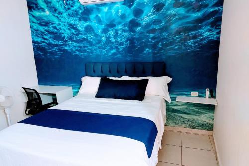 a bedroom with a bed with a painting on the wall at Loft 15 comodo y confortable , cerca del centro de gobierno , galerias mall, consulado , CAS , Pepsi in Hermosillo