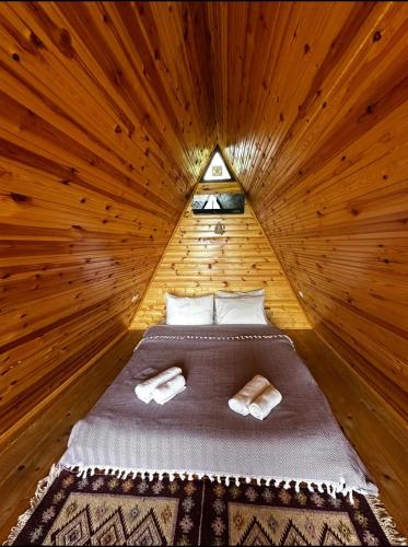 a bedroom with a bed in a wooden room at Wayside Cottage in Batumi