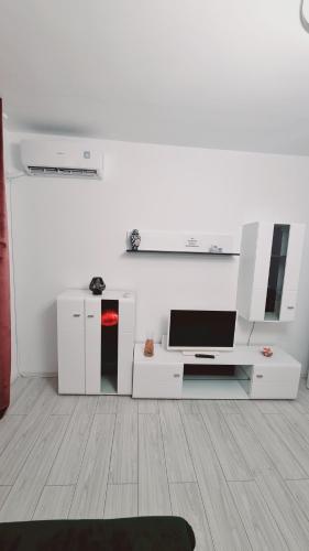 a white living room with a tv and a table at Apartament pe pietonala nr1 in Hunedoara