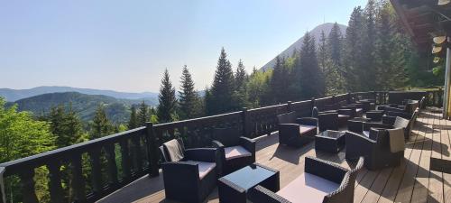a deck with chairs and tables on a balcony with mountains at Kurhotel Renona Rehabilitation in Semmering