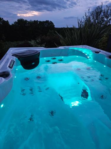 a swimming pool lit up at night at Le Coucher de Soleil Spa in Bessens