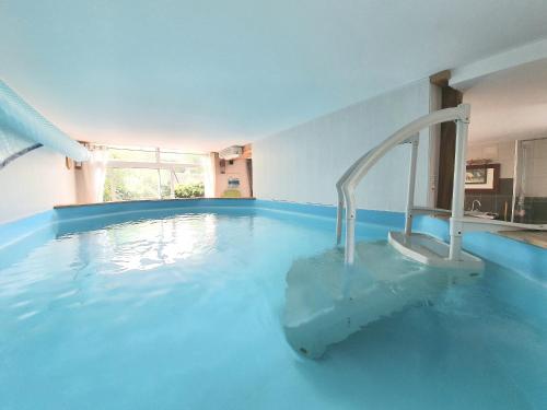 - une piscine d'eau bleue dans une chambre dans l'établissement Gite de la Verrière, 12 personnes, 5 chambres, à Portieux