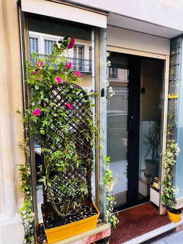 une porte ouverte avec des fleurs roses sur un bâtiment dans l'établissement Amber Apartment Nice - Central Highlights and Beach, à Nice