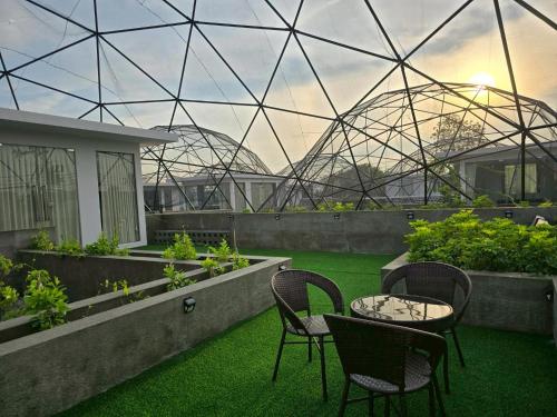 a patio with chairs and a table and a glassarium at The Ten Poolvilla Huahin in Hua Hin