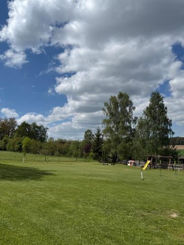 a large field with a park with a playground at Chaloupka Pomněnka na Lipce in Nasavrky