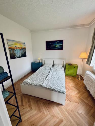 a bedroom with a bed and a painting on the wall at Csodakertes kisház Balatonfűzfőn in Balatonfůzfő