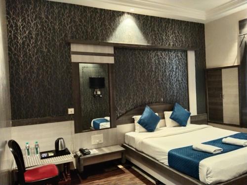 a hotel room with two beds and a mirror at Hotel Kiara Eshosans Palace in Shirdi
