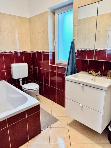 a bathroom with a sink and a toilet and a mirror at Csodakertes kisház Balatonfűzfőn in Balatonfůzfő