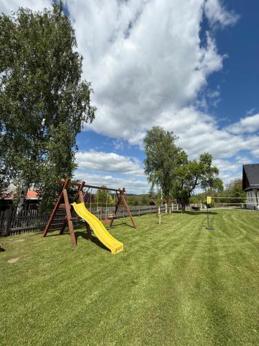 a playground with a yellow slide in a yard at Chaloupka Pomněnka na Lipce in Nasavrky