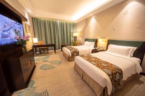 a hotel room with two beds and a flat screen tv at Jin Jiang Nanjing Hotel in Nanjing