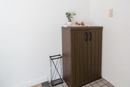 a wooden cabinet with a plant on top of it at TIDA Ishigaki in Ishigaki Island