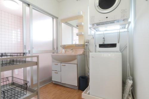 a small kitchen with a sink and a microwave at TIDA Ishigaki in Ishigaki Island
