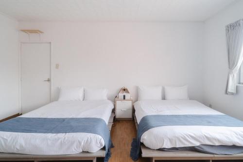 two beds sitting next to each other in a room at TIDA Ishigaki in Ishigaki Island