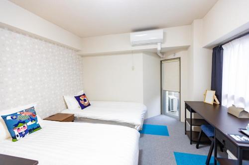 a hotel room with two beds and a desk at ksi南常盤台301 in Tokyo
