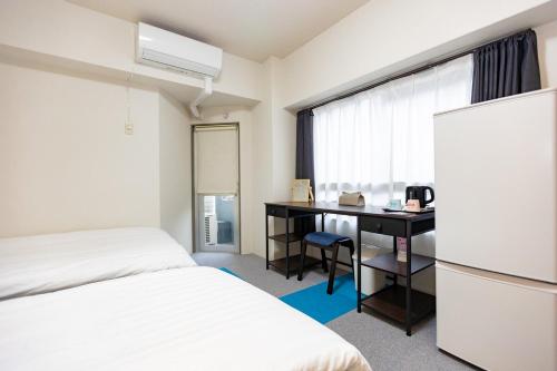 a hotel room with a bed and a desk and a window at ksi南常盤台301 in Tokyo