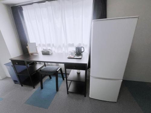 a desk with a white refrigerator in a room at ksi南常盤台301 in Tokyo