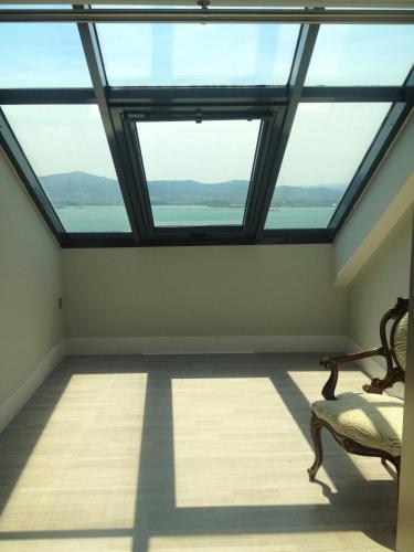 a room with two windows and a chair in a room with a view at Hotel Art Santander in Santander