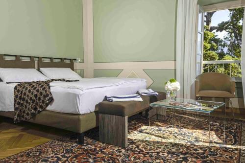 a bedroom with a bed and a table and a window at Hotel Bogliaco in Gargnano