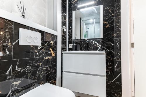 a bathroom with black marble walls and a white refrigerator at 6 Stylish & Comfortable Studios , Heart of Gent in Ghent