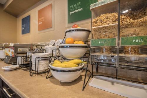 a counter with bowls of fruit and other food at Comfort Inn in Chilliwack